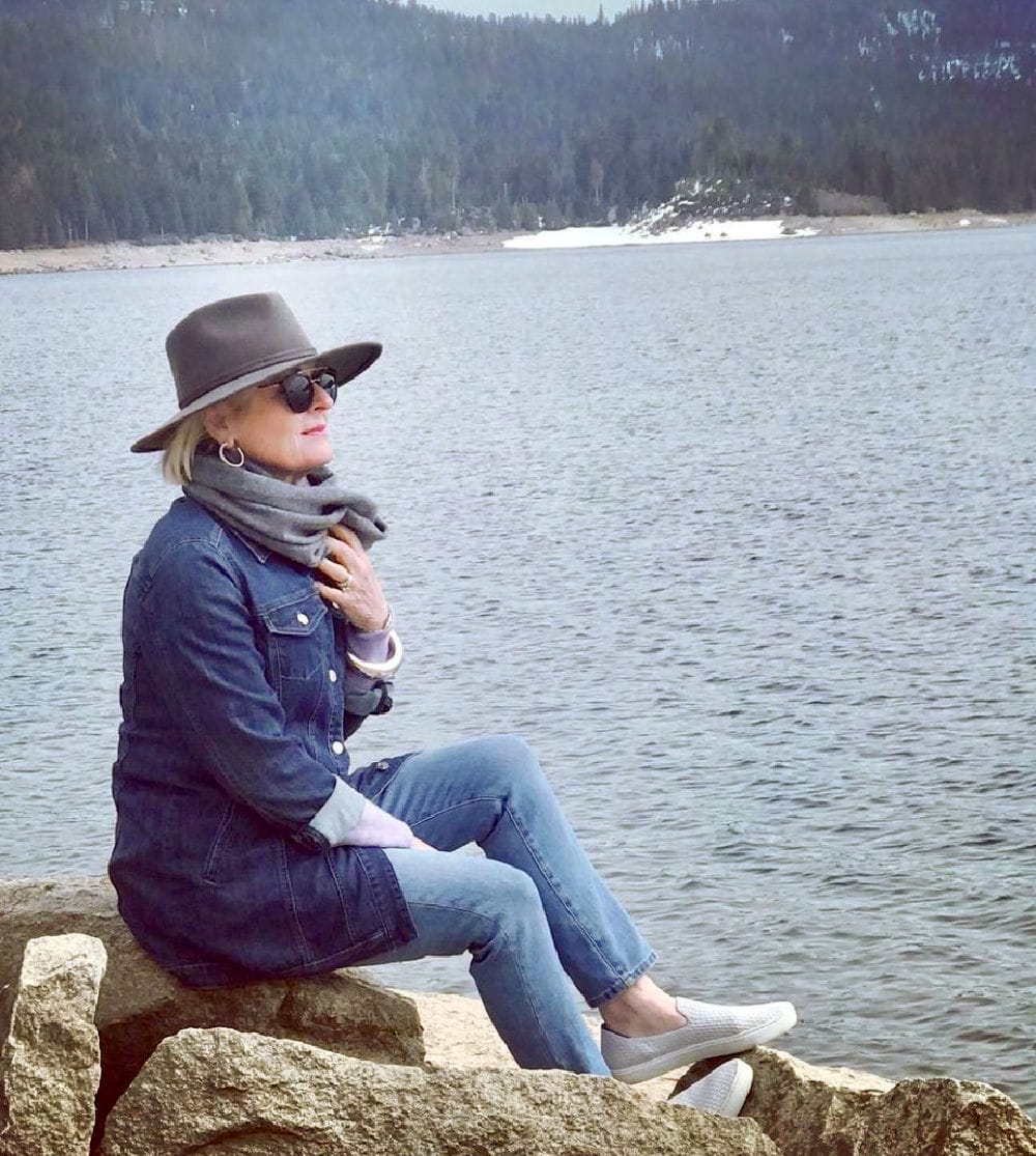 woman sitting on rocky coast