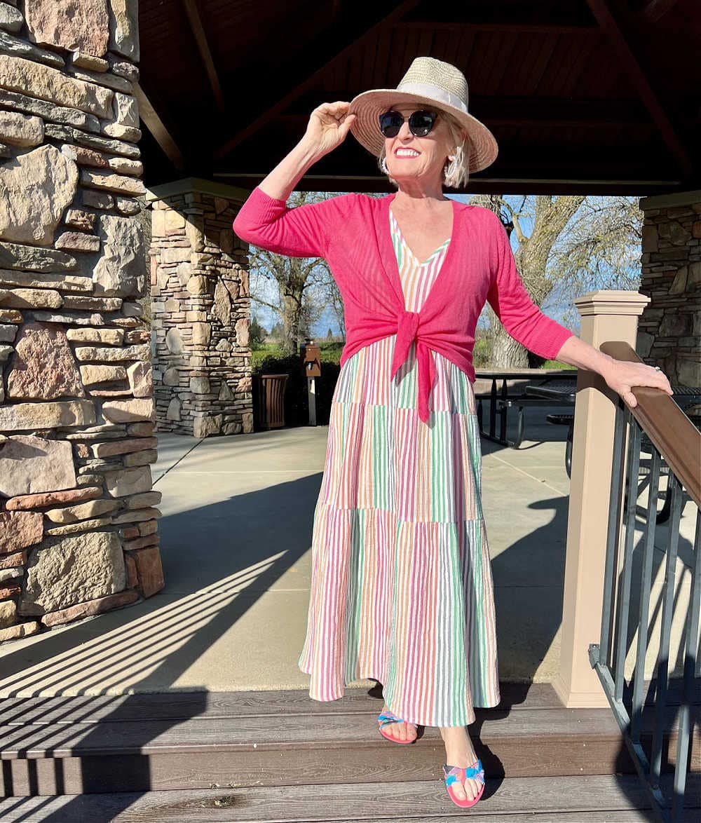 woman in striped dress holding her hat