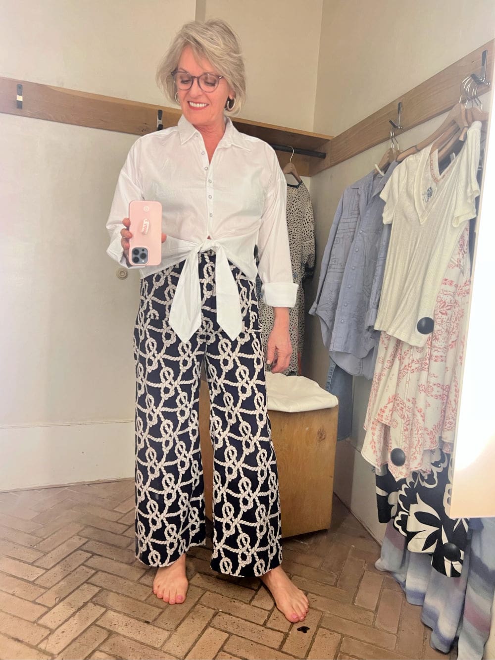 blonde women in anthropologie dressing room wearing blouse and pants