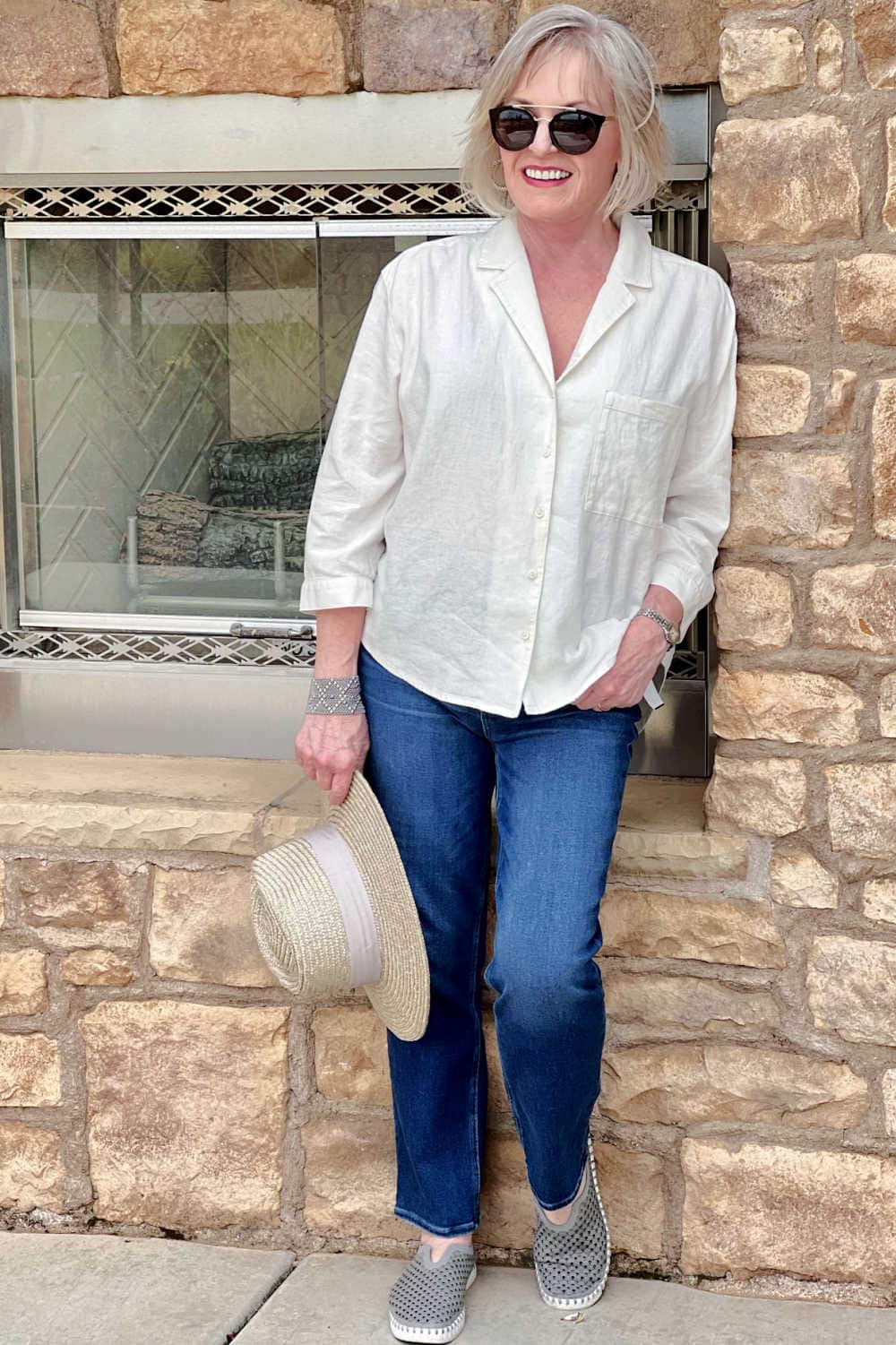 woman wearing paige jean outfit with linen shirt and slip on sneakers