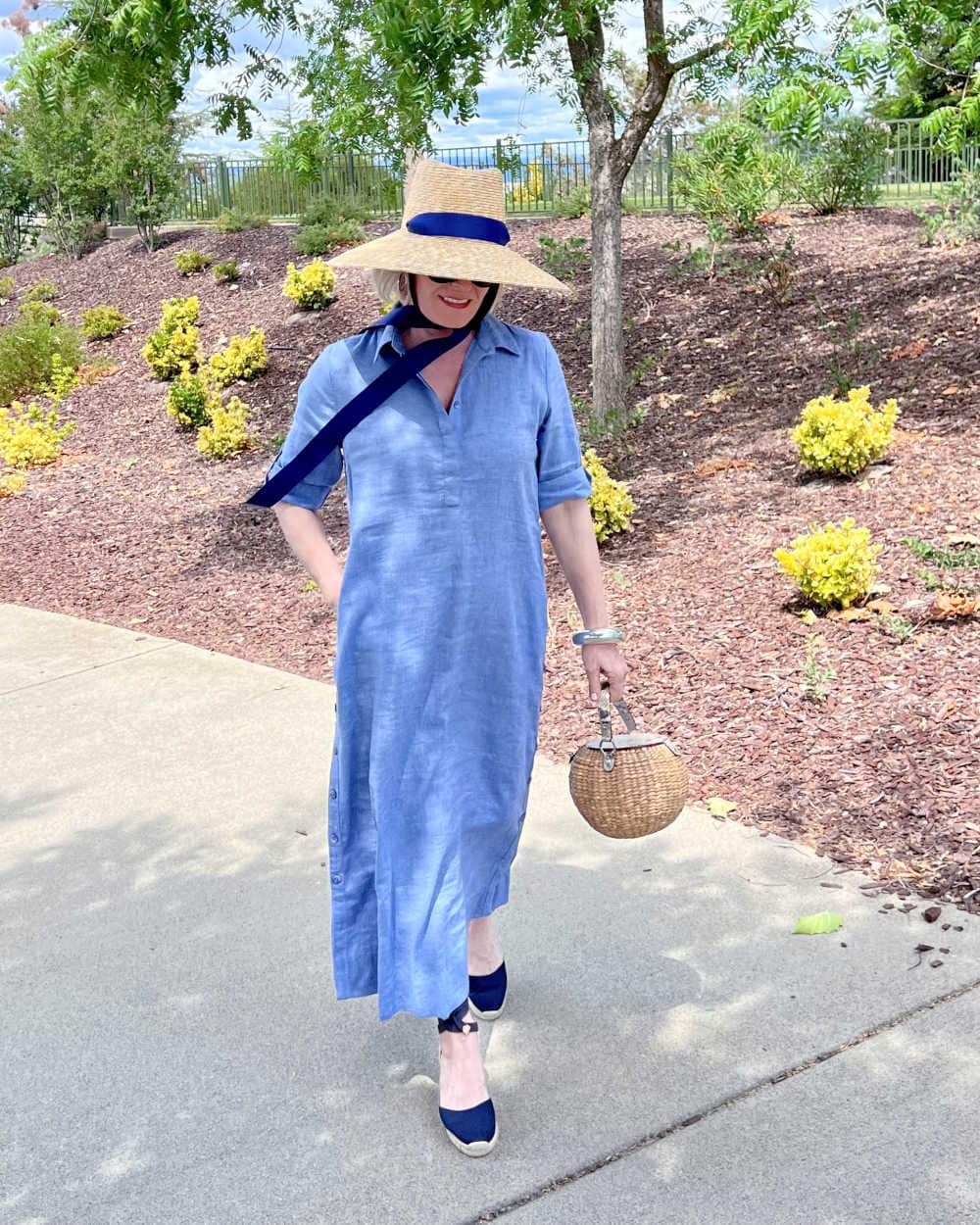 woman wearing large whimsical sunhat and blue sundress
