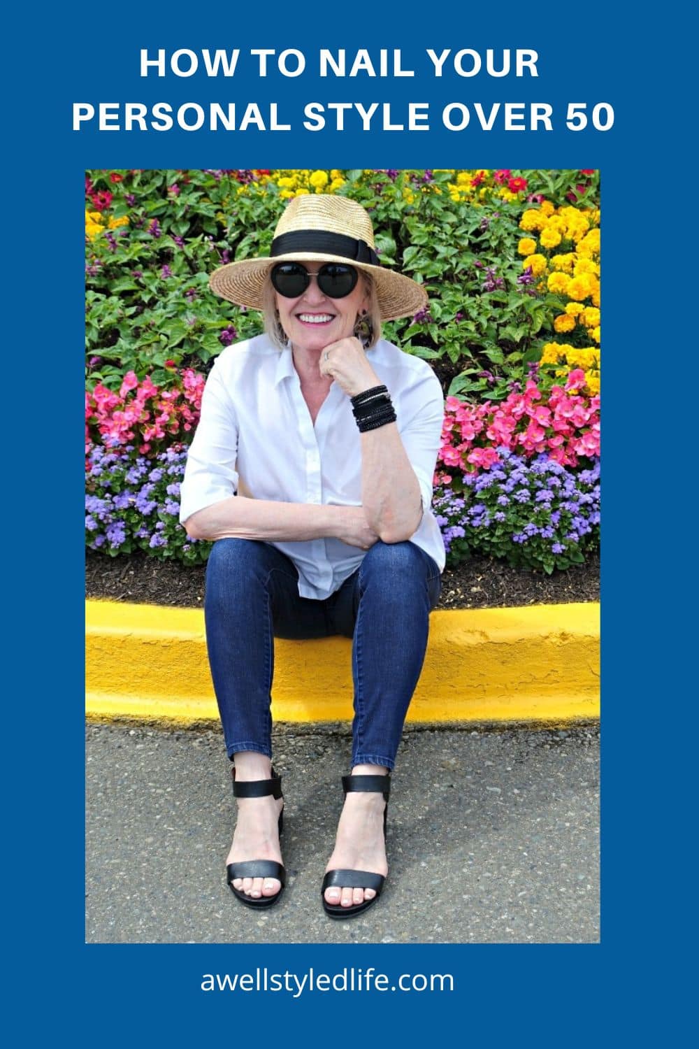 woman sitting on curb in hat and jeans