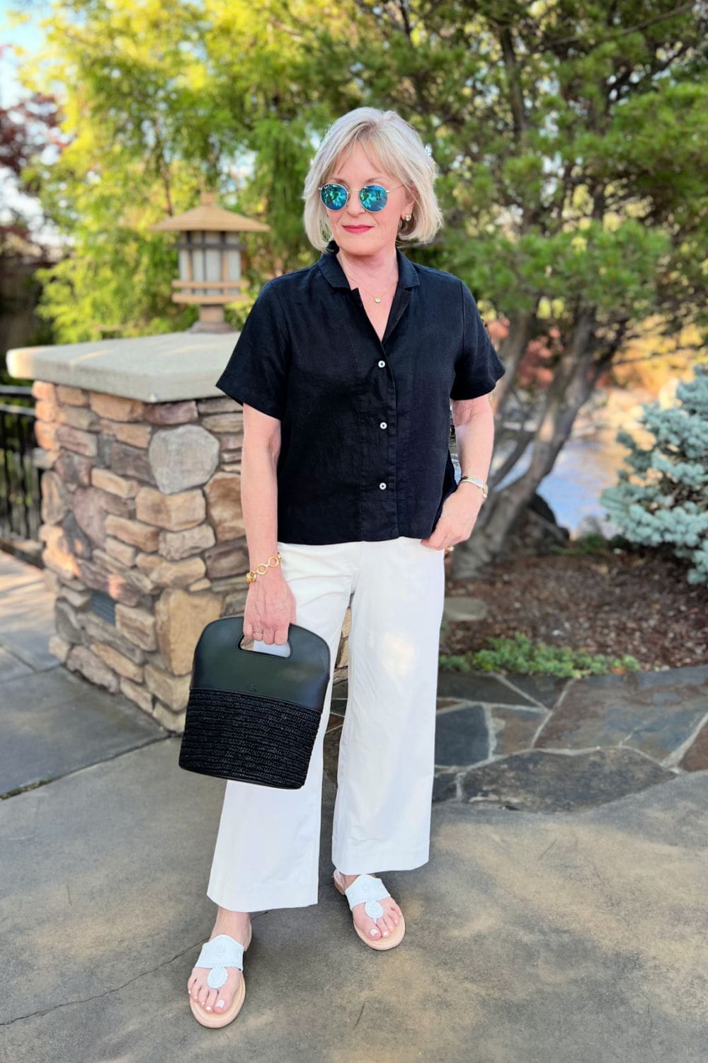 woman wearing black top and white pants