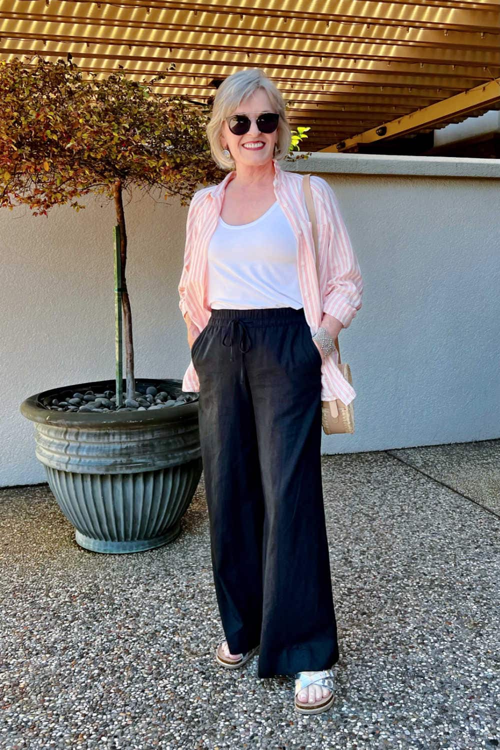 woman wearing b udget friendly outfit of black pants and striped shirt