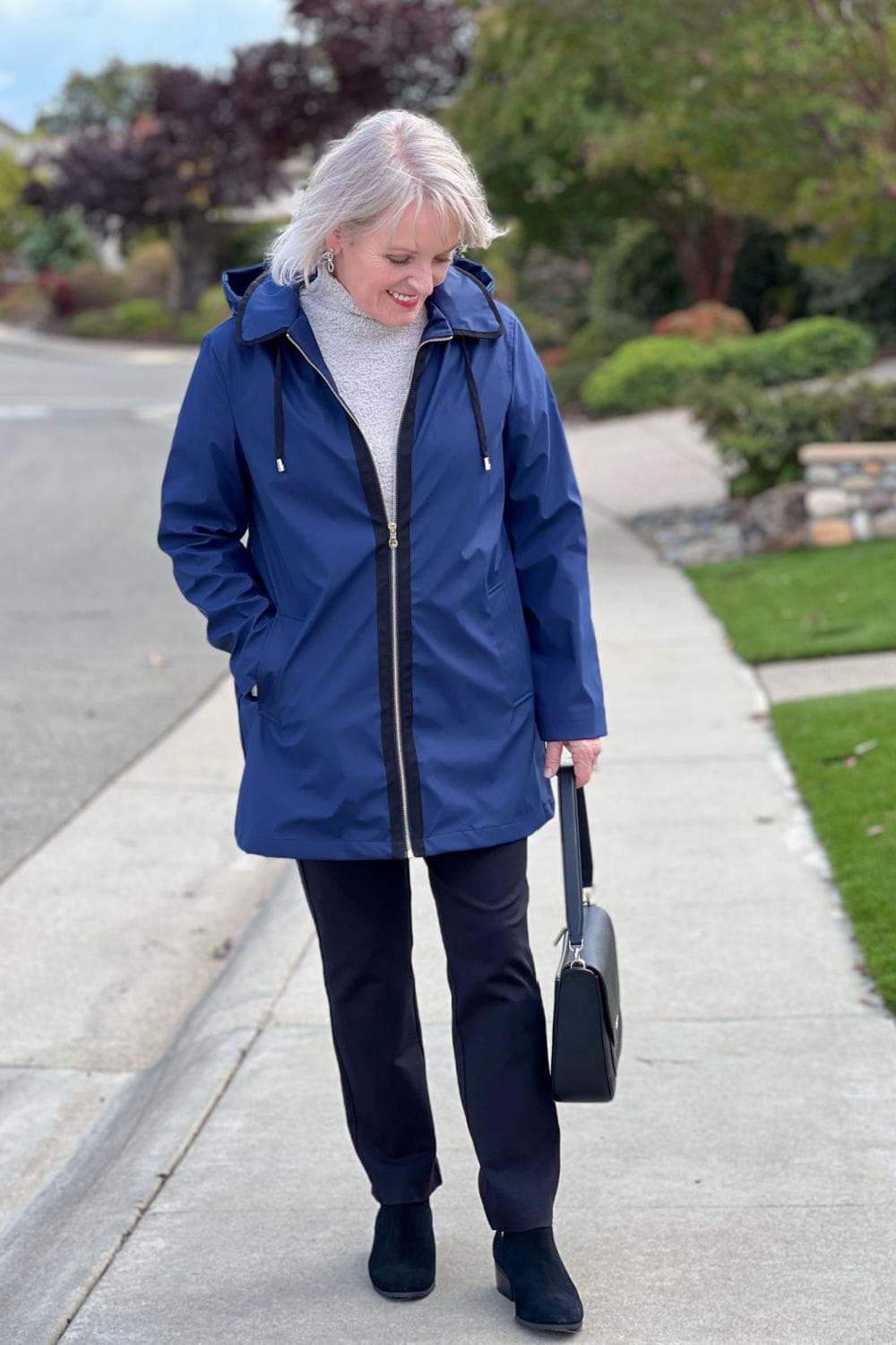 woman wearing kate spade navy rain jacket, black ponte pants and kate spade bag from nordstrom rack