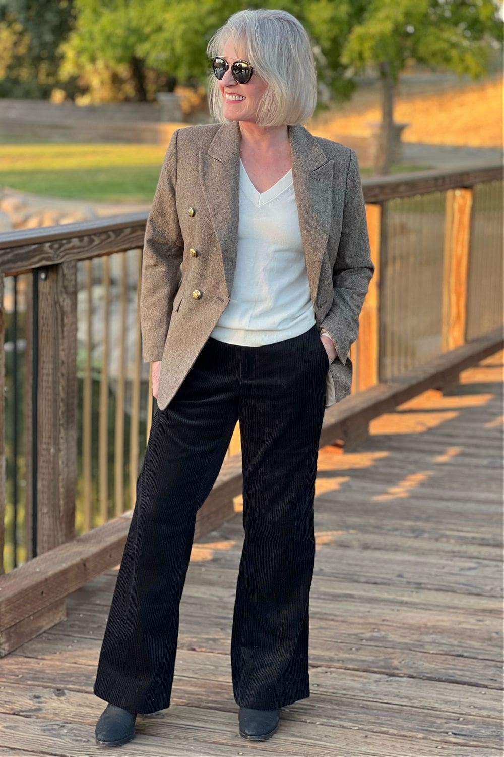 WOMAN WEARING TWEED BLAZER AND BLACK BOOTCUT PANTS FROM BANANA REPUBLIC FACTORY