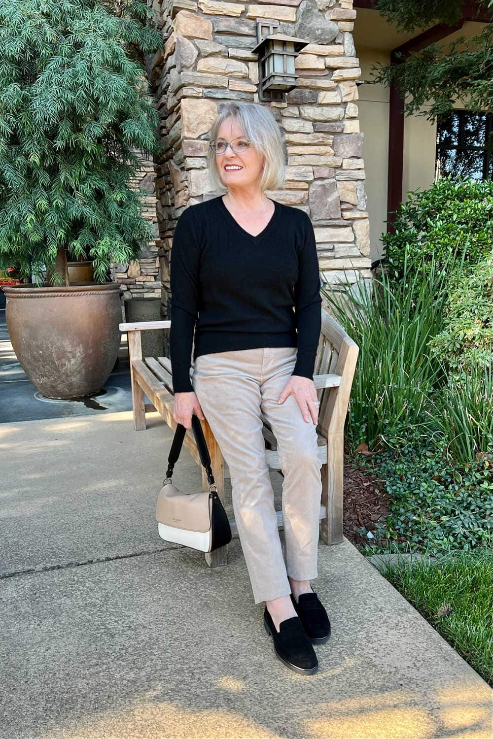 BLONDE WOOMAN WEARING BLACK QUINCE CASHMERE SWEATER WITH FAWN KUT FROM KLOTH CORDUROY PANTS