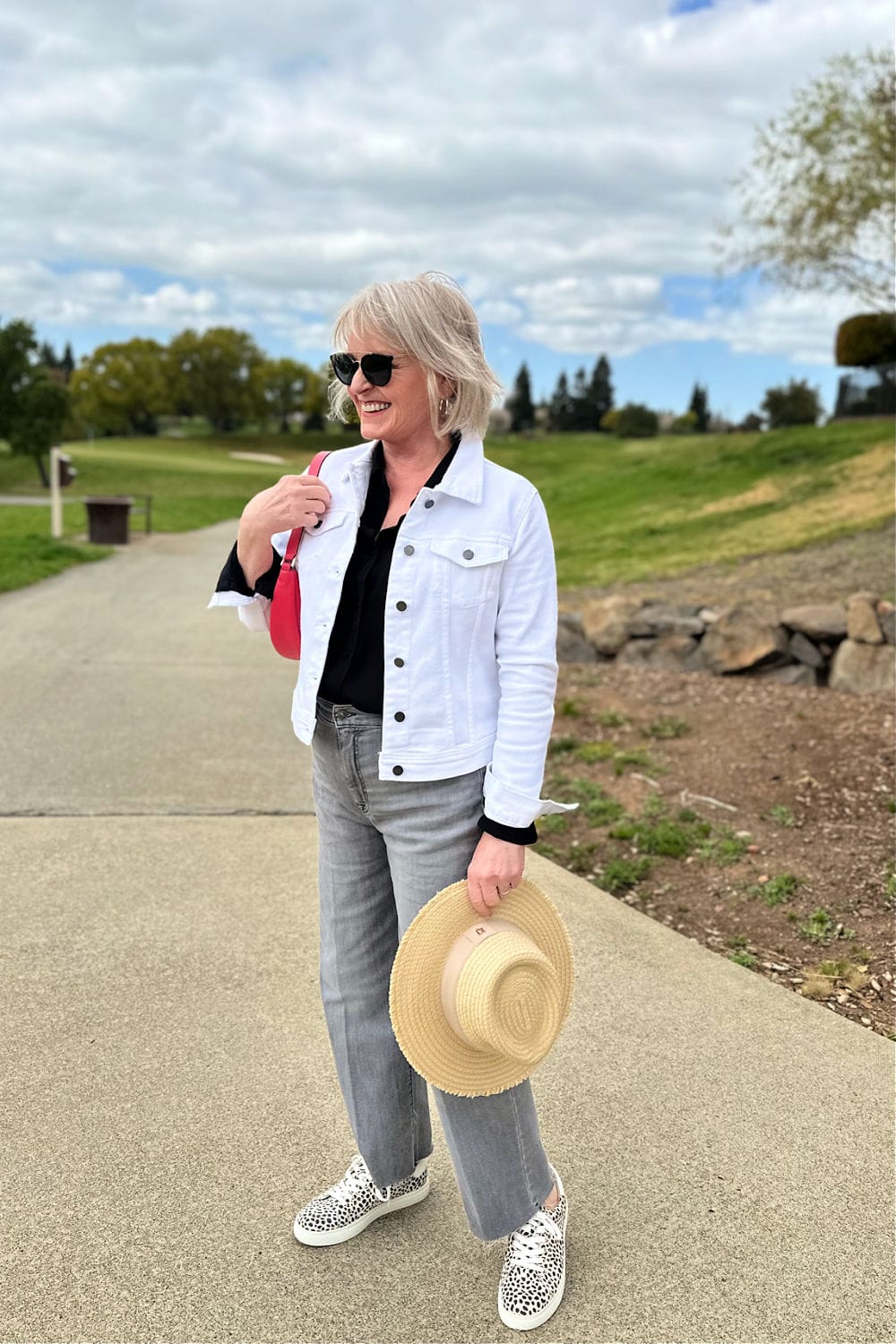 woman wearing double denim outfit with straw hat and leapard pront shoes