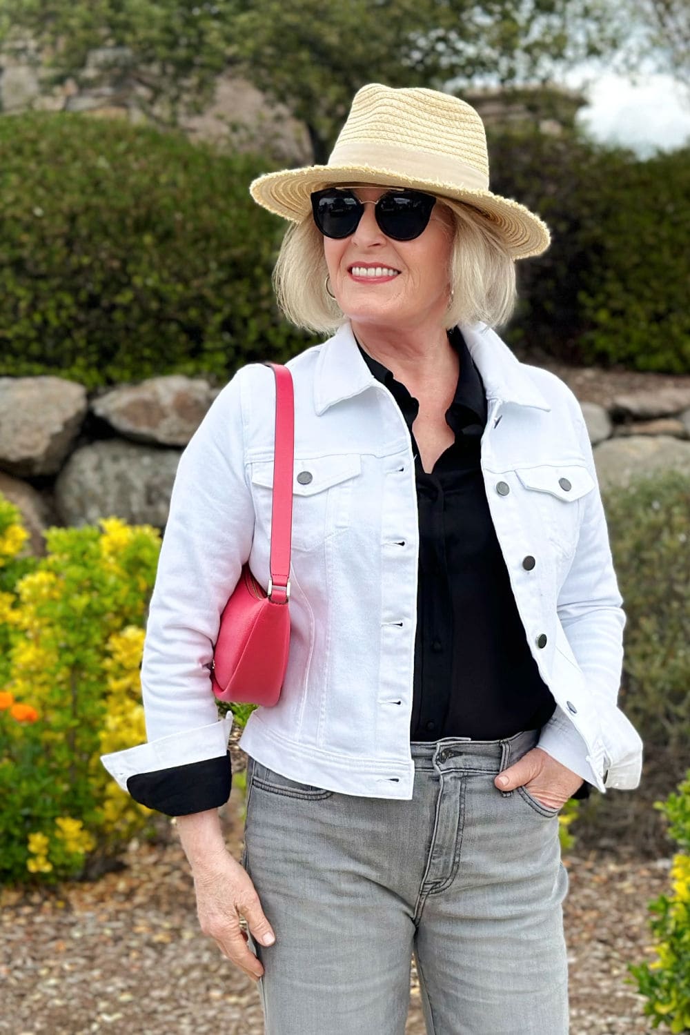 woman wearing white denim jacket and gray jeans in double denim outfit for spring