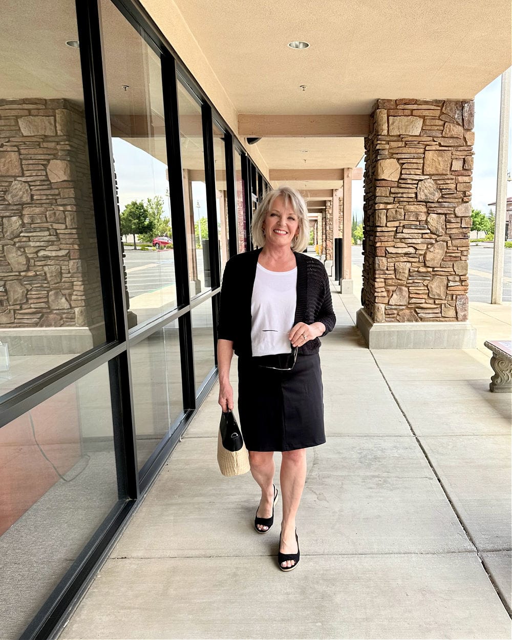 woman walking in black skort and wegde sandals