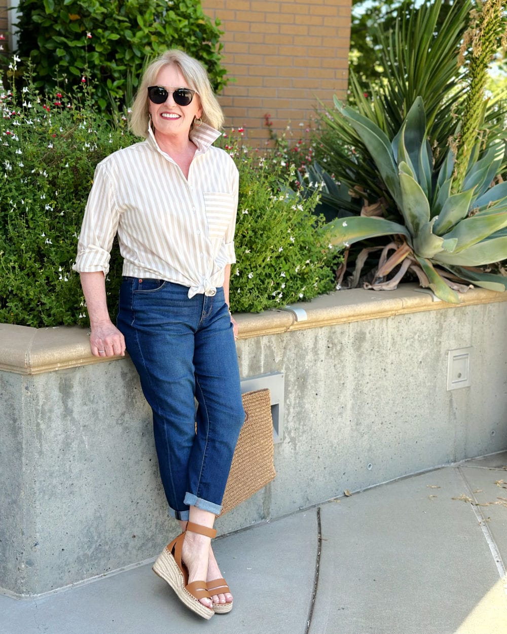 woman leaning on wall wearing nordstrom rack easy care shirt and boyfriend jeans