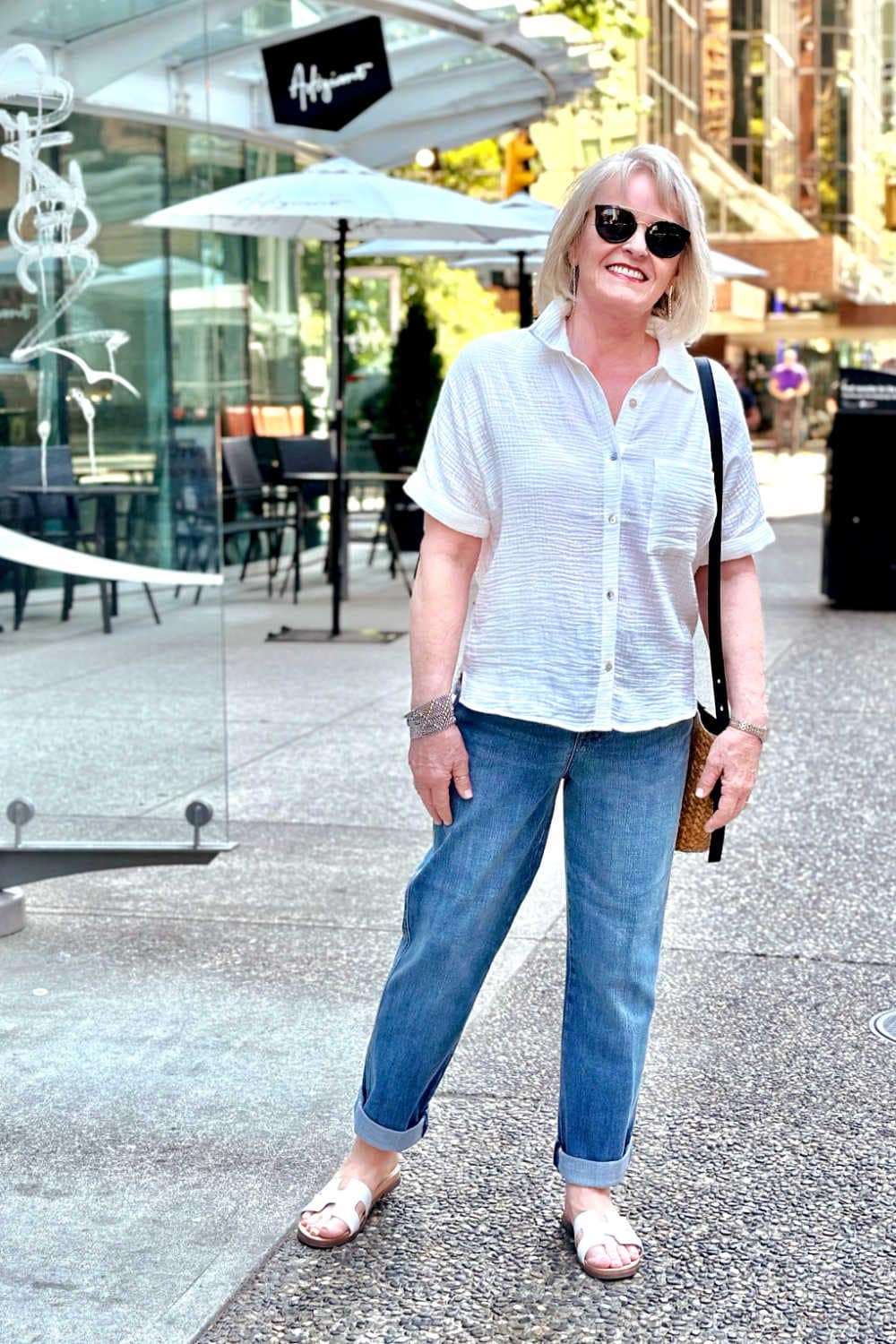 woman wearing ivory cotton camp shirt and boyfriend jeans
