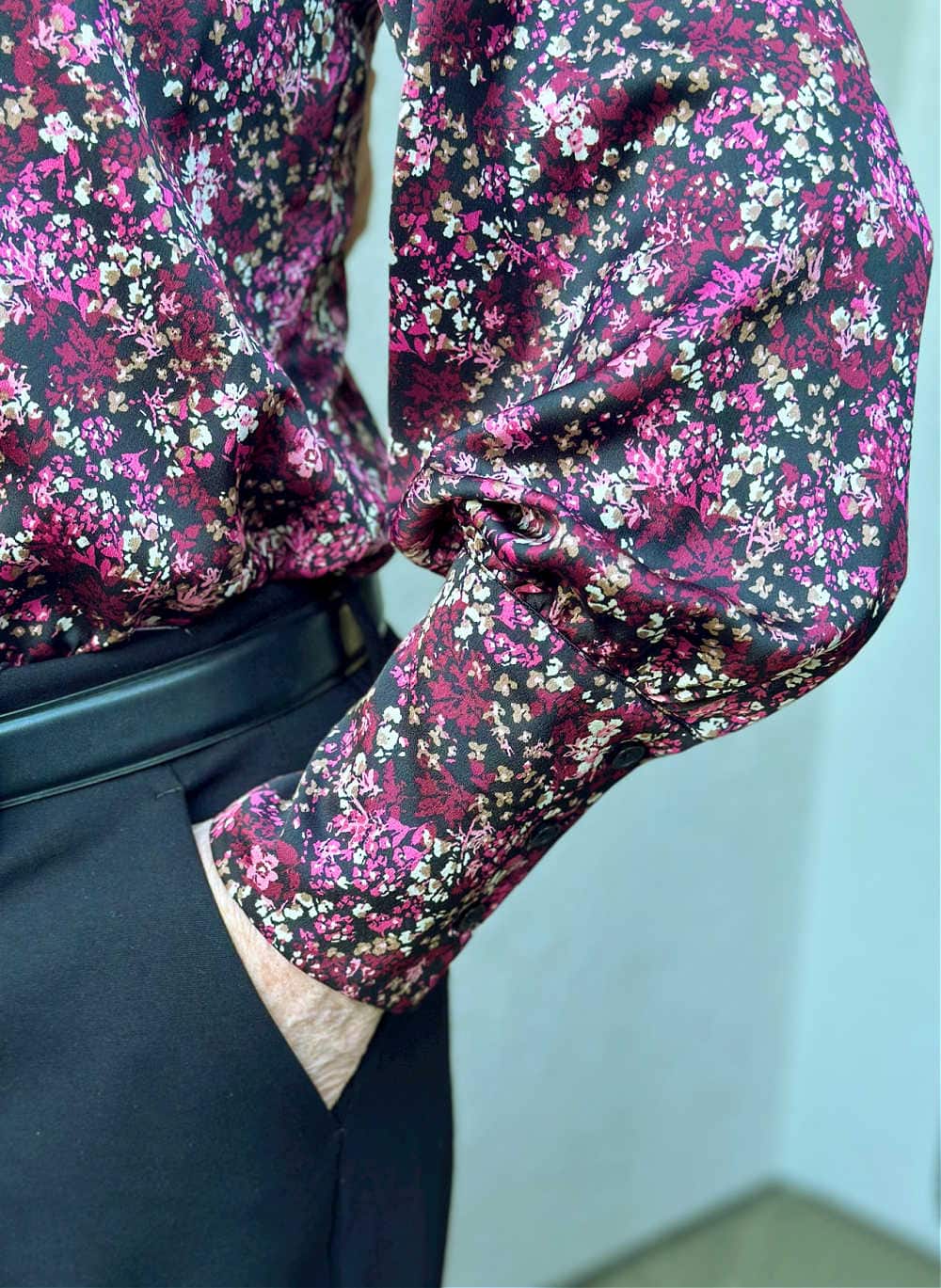 close up of sleeve detail of dark floral blouse in deep ruby