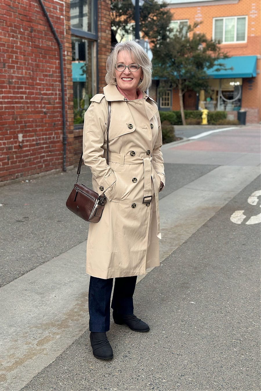 woman in alley wearing classic london fog trench coat