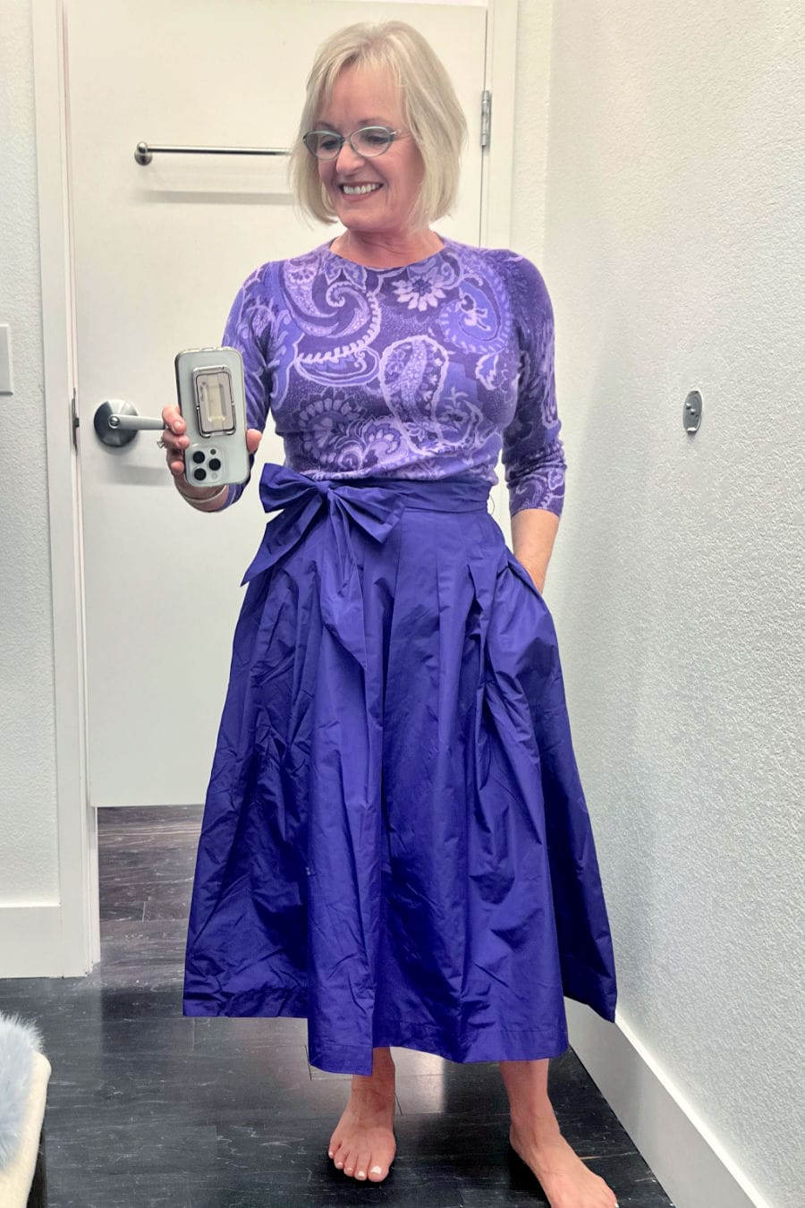 woman wearing purple talbots holidat skirt and cashmere sweater in dressing room