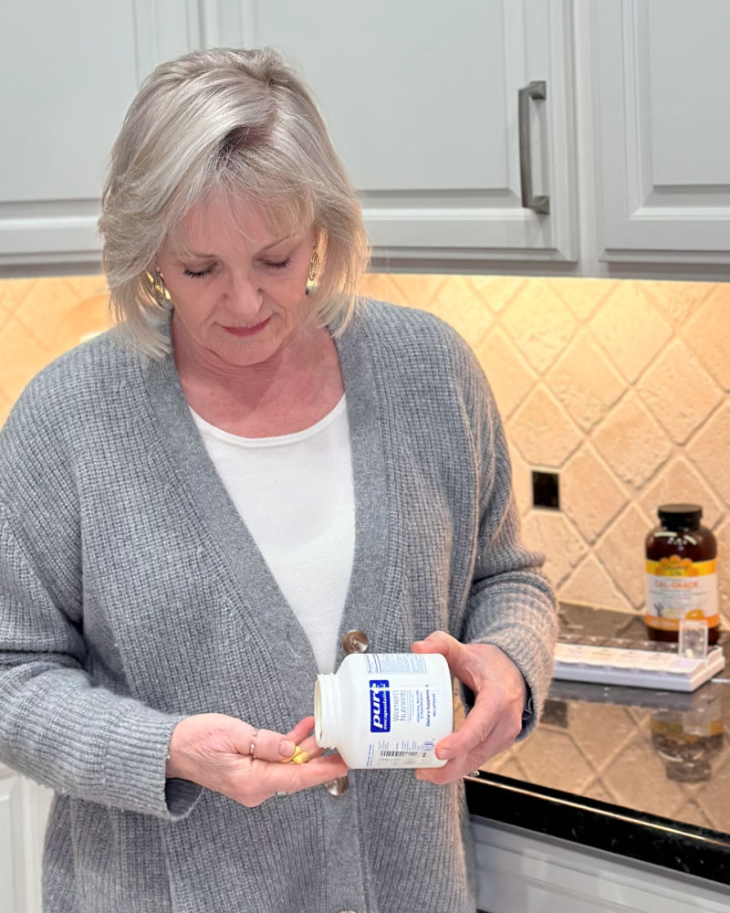 woman taking multi vitamin to support her healthy aging