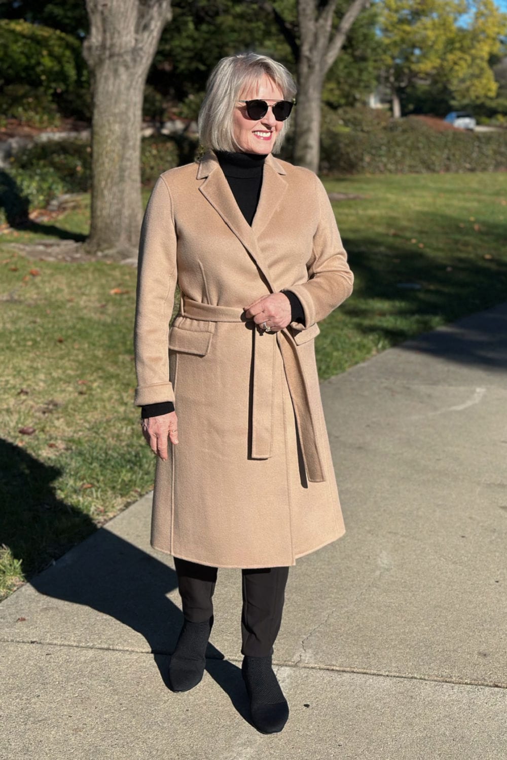 woman wearing Quince cashmere wrap coat over column of black