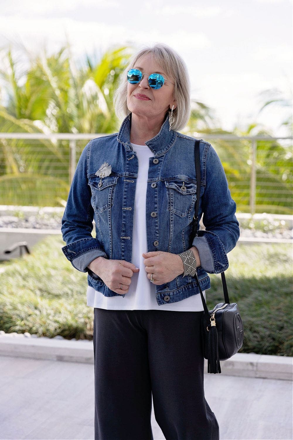 artistic brooch worn on seam over pocket on denim jacket