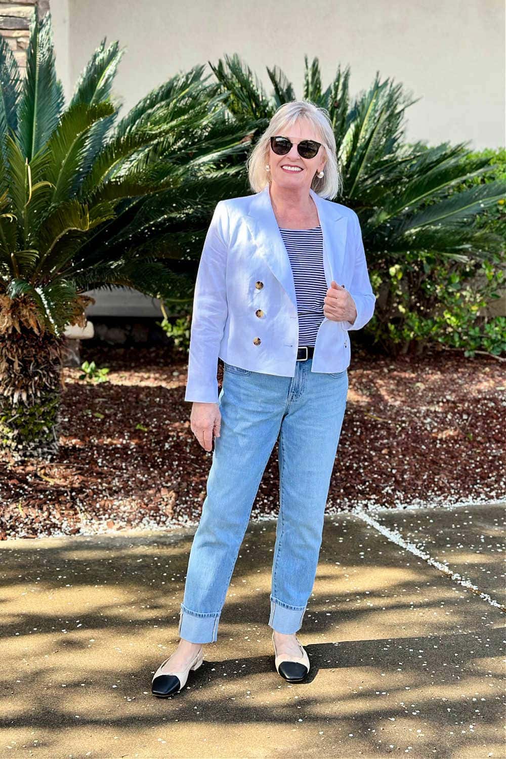 woman wearing elevated style over 60 with white cropped blazer and cuffed jeans