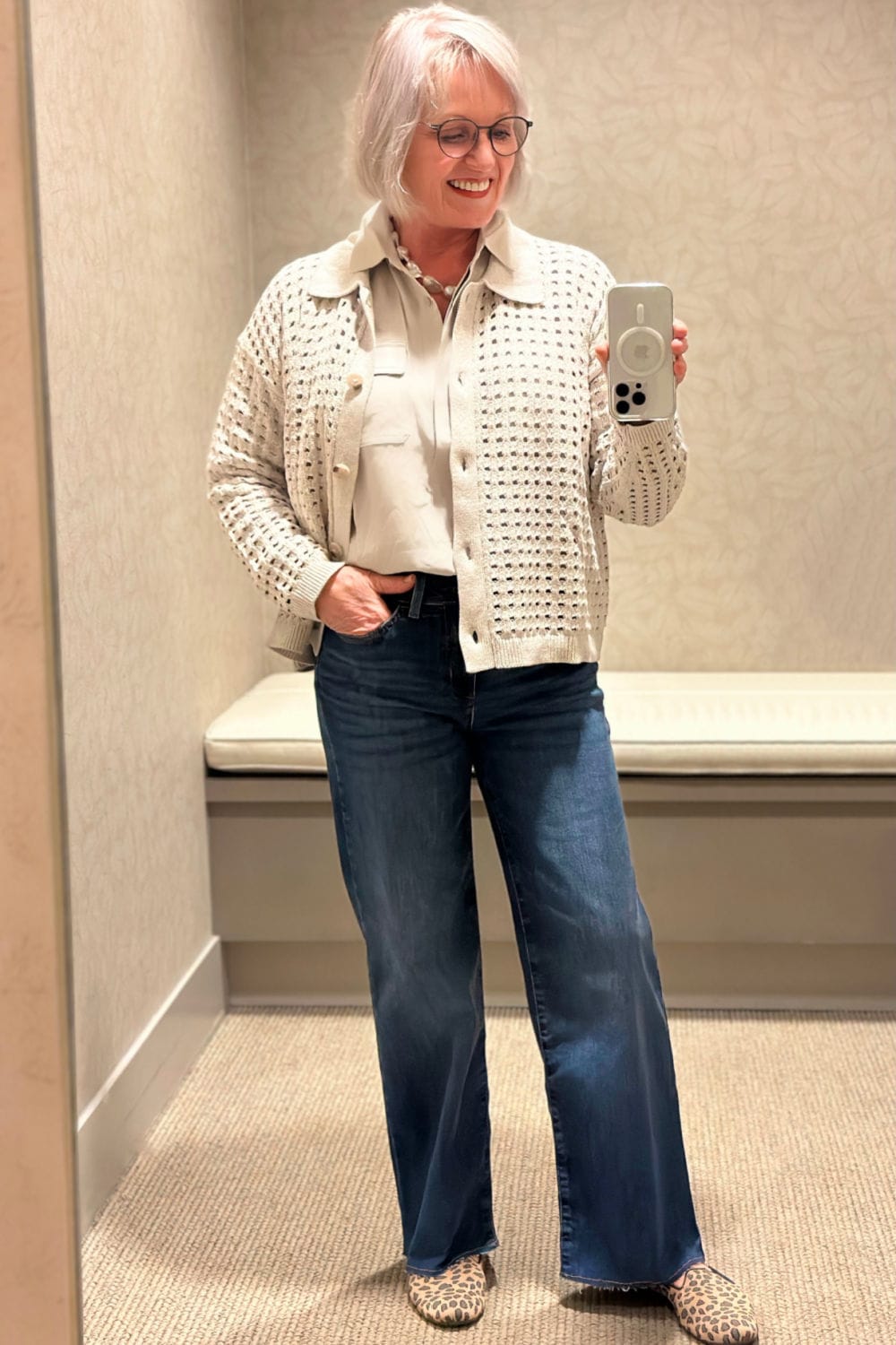 woman wearing open wear cardigan and blue jeans in j jill dressing room