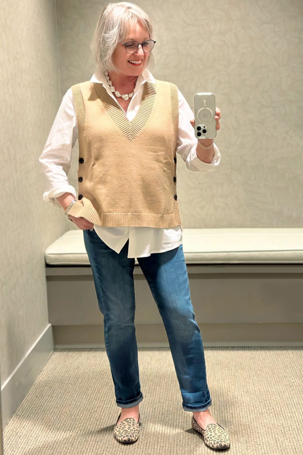 jennifer connolly of a well styled life in the j jill dressing room wearing white shirt knit vest and jeans