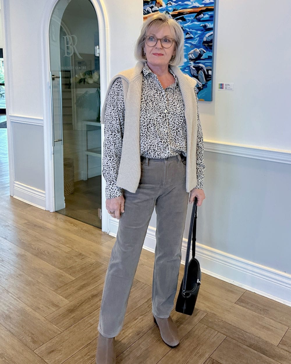 JENNIFER OF A WELL STYLED LIFE WEARING EILEEN FISHER CORDUROY PANTS WITYH ANIMAL PRINT RAILS BLOUSE AND MUNRO BOOTIES