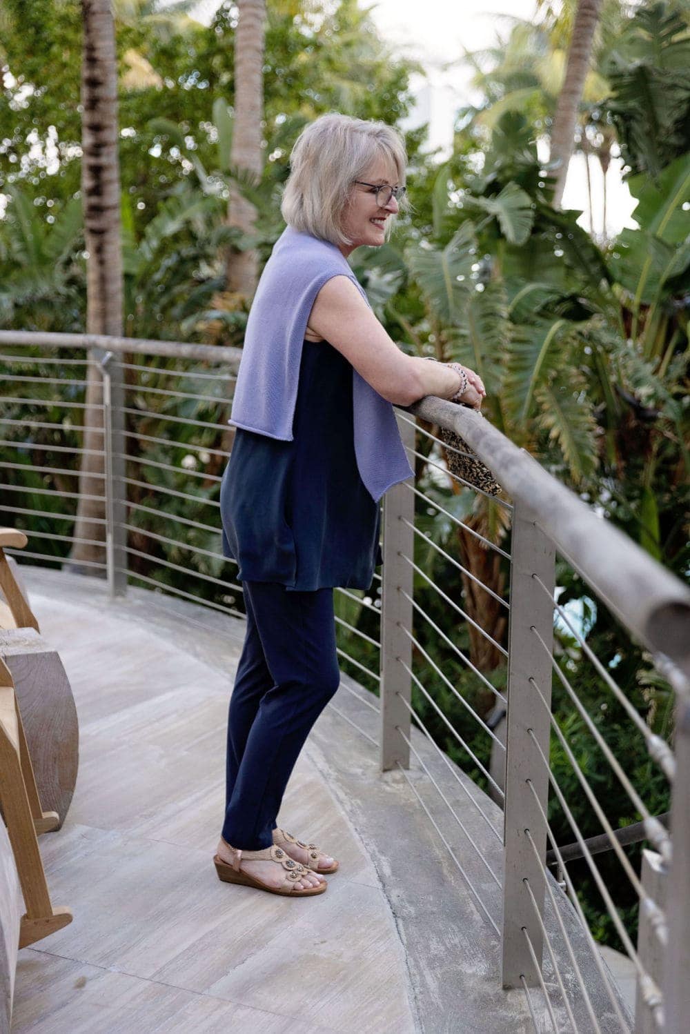woman looking over railing wearing eileen fisher crepe pants and purple sweater