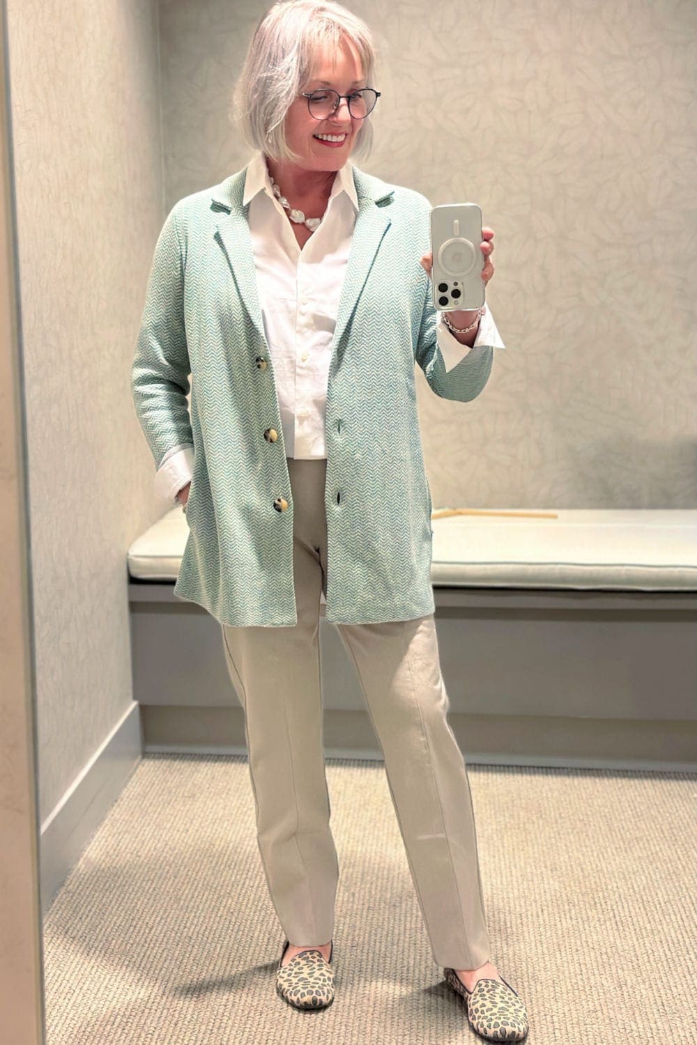 woman in j jill dressing room in green blazer and twill pants