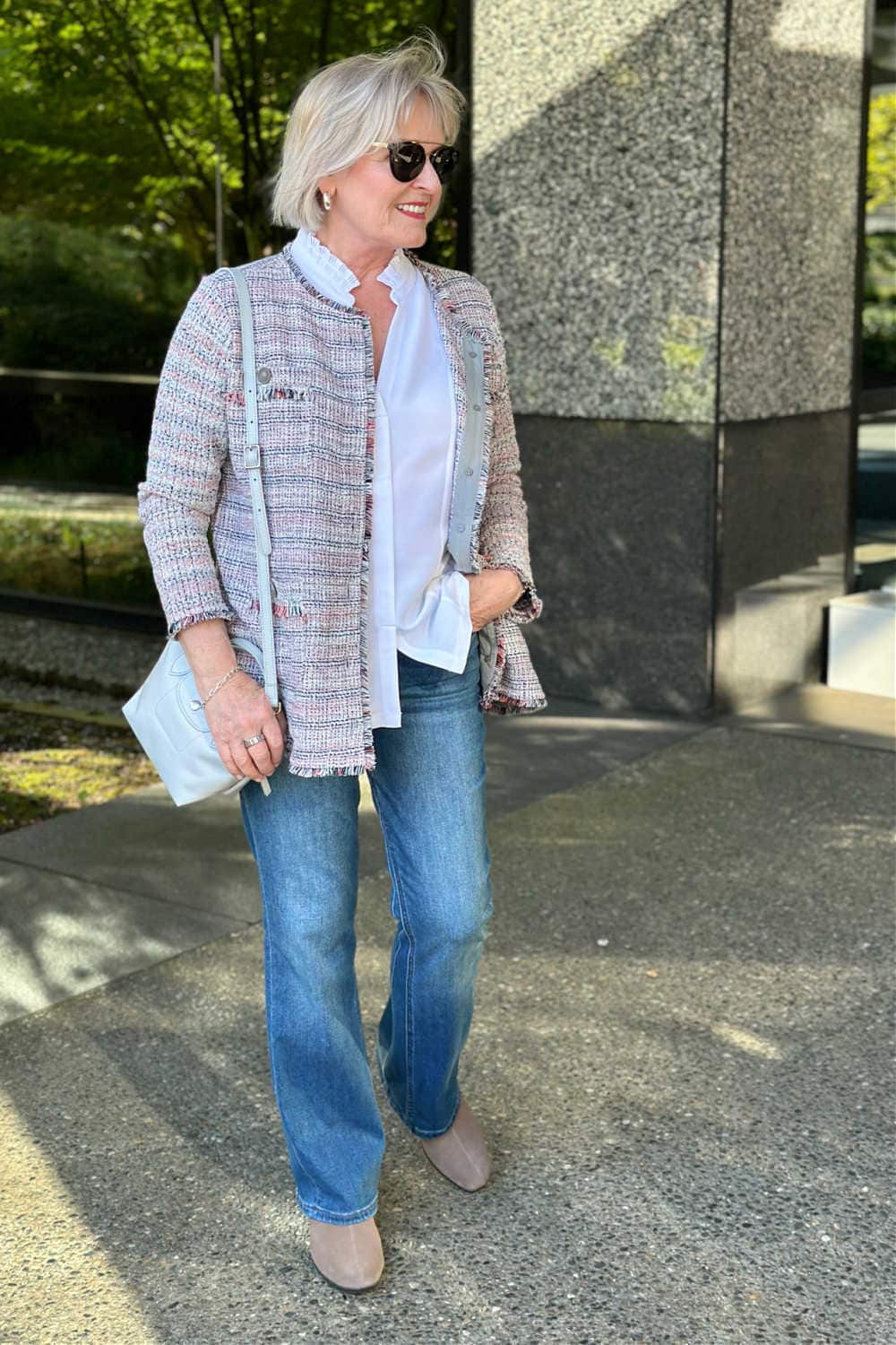 woman wearing tweed jacket with white blouse and flare leg jeans