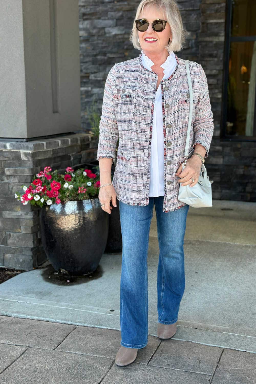 older silver haired woman wearing flare jeans and tweed blazer
