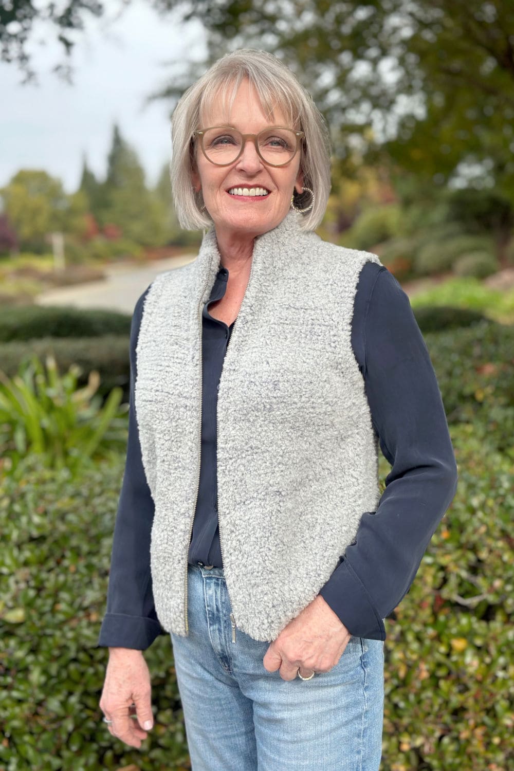 woman wearing bouclê vest over blouse and jeans for a casual lifestyle