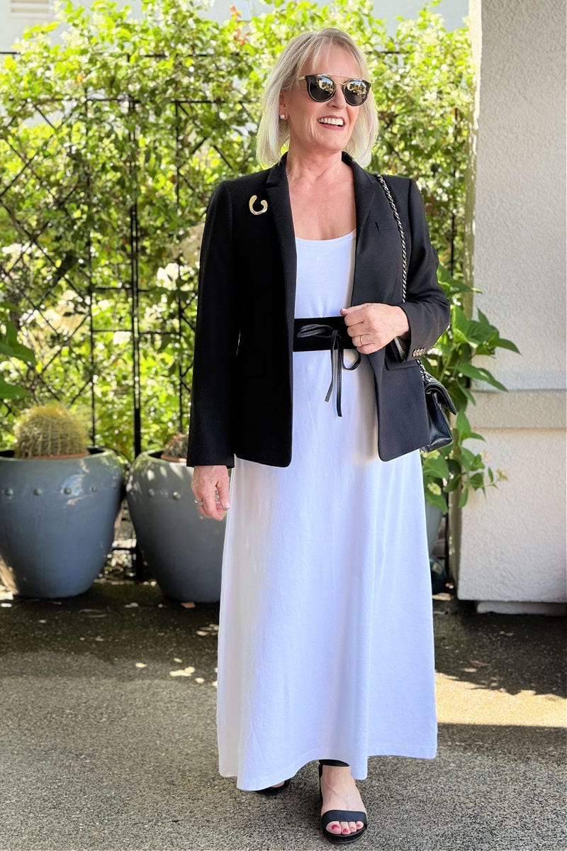 Chic dinner outfit with black blazer, obi belt, and brooch layered over a simple cotton dress
