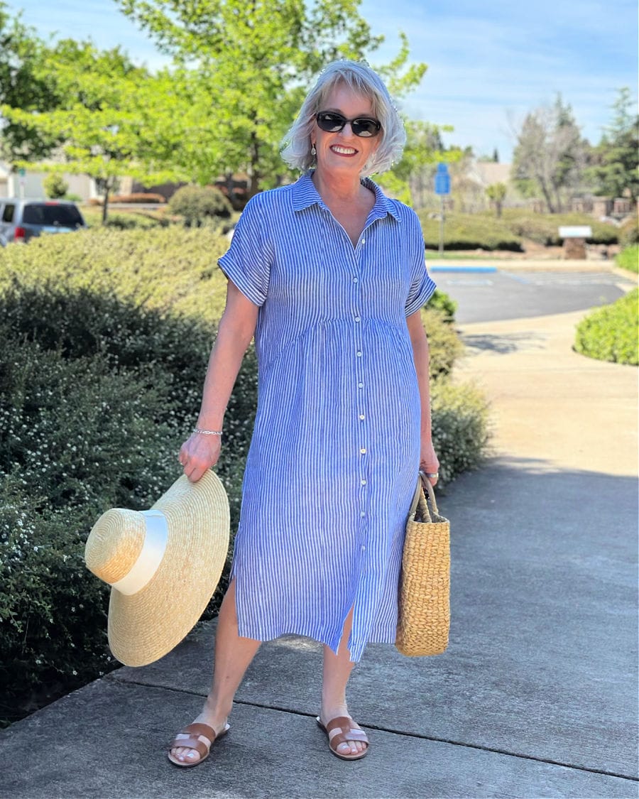 Woman over 60 wearing Talbots striped shirtdress with sandals and straw tote, stylish summer outfit idea