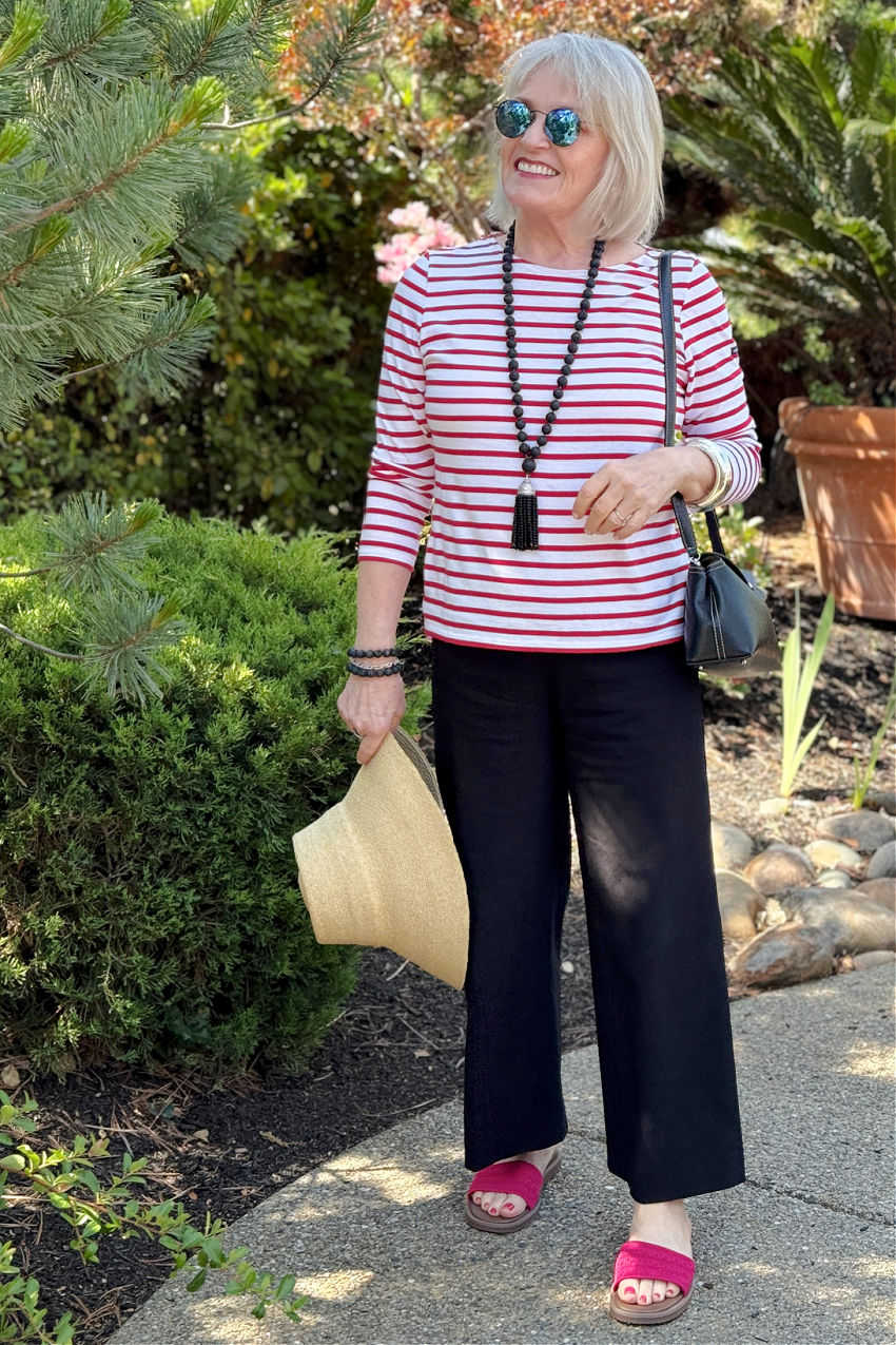 Playful and colorful birthday outfit for older woman featuring a red-and-white striped top, black pants, and bright pink sandals