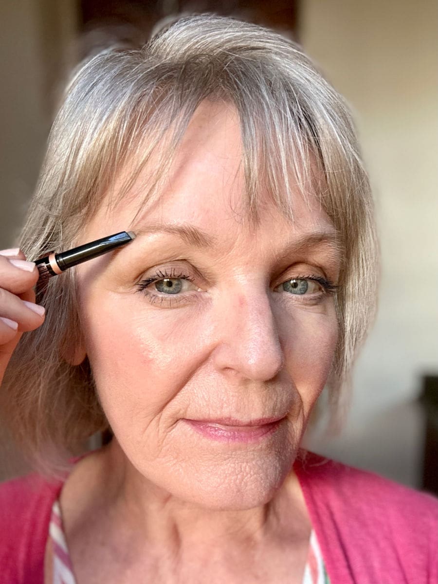 Filling in thinning eyebrows with a soft brow pencil for women over 60