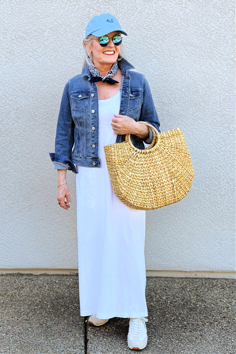 Sporty look with t-shirt dress, denim jacket, sneakers, and baseball cap for casual day out over 60