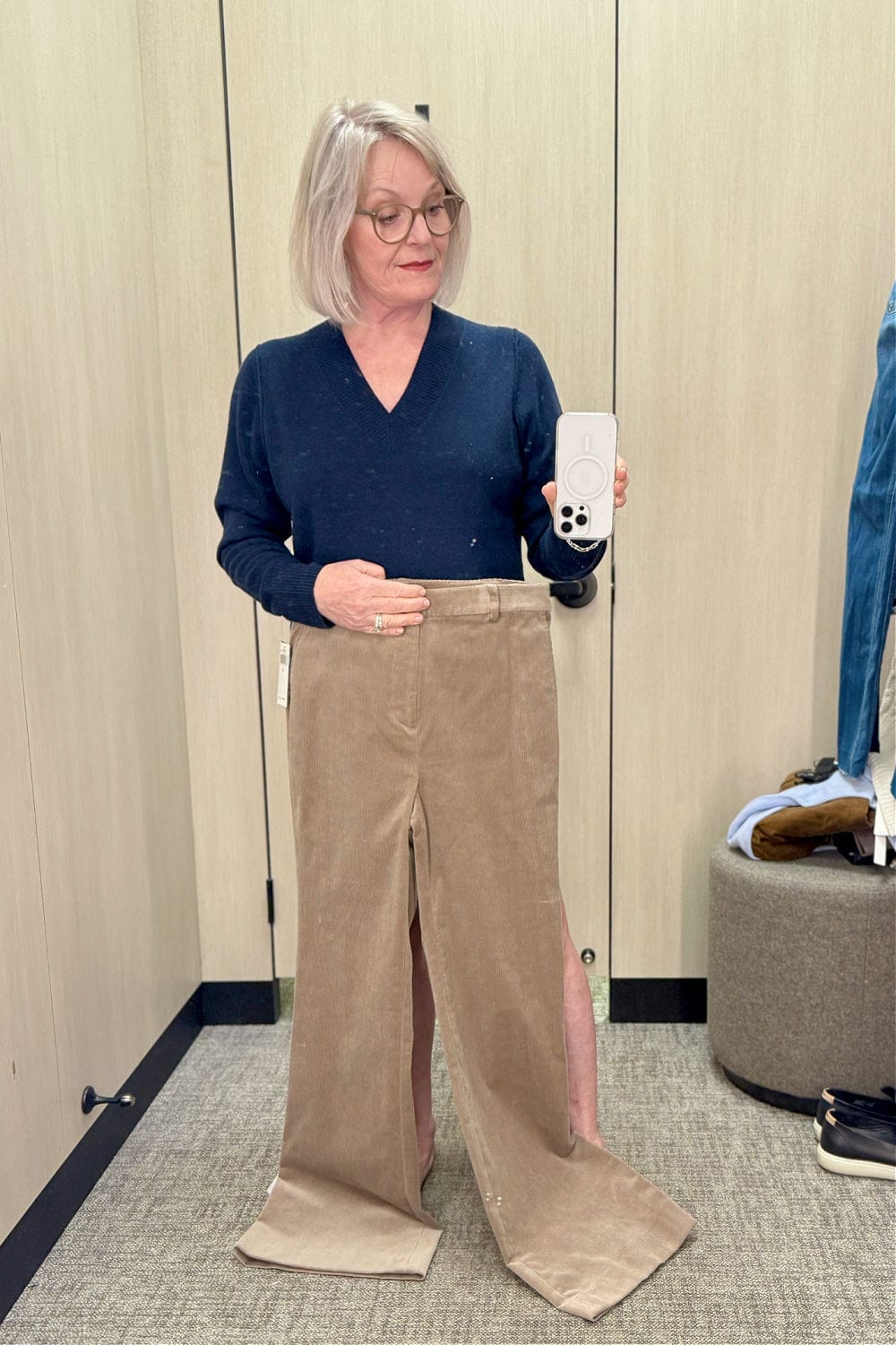 woman trying on pants in her size that are way too long