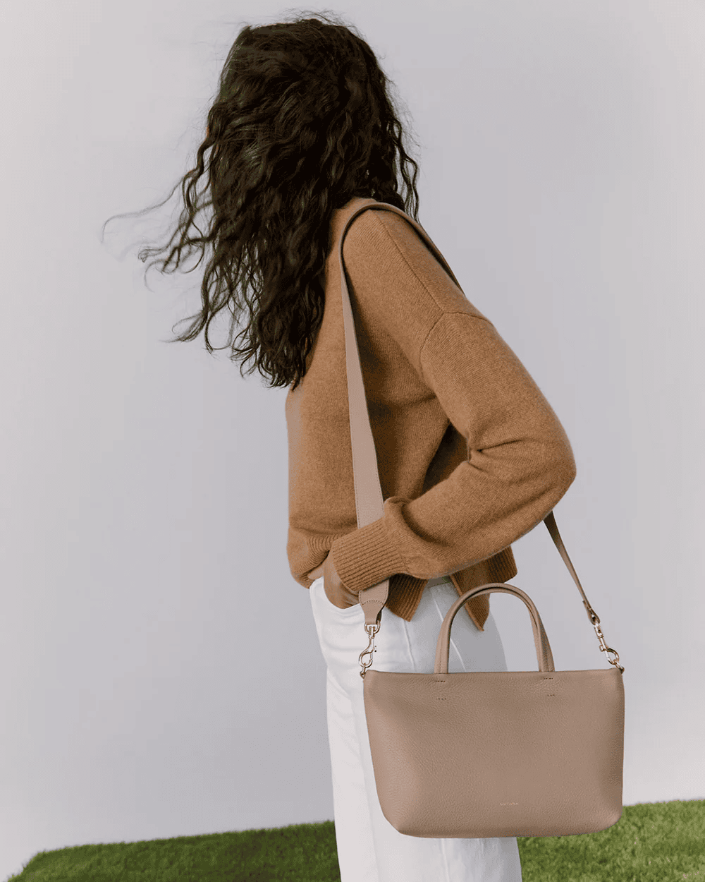 Cuyana Mini Easy Zipper Tote in cappuccino leather with slim structured shape, top zipper, and crossbody strap.