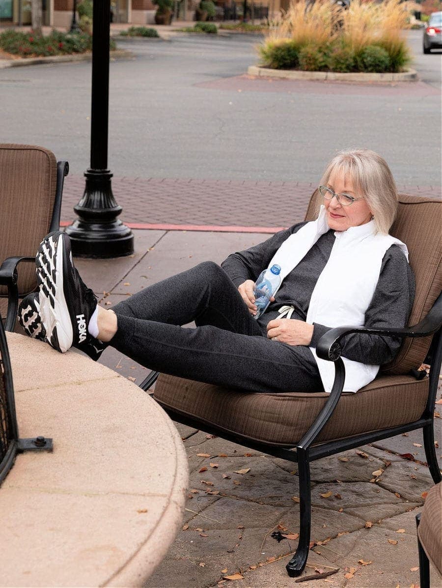 Silver haired woman in workout gear wearing hoka clifton sneakers
